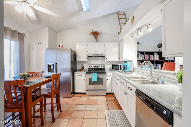 kitchen with light tile patterned floors, stainless steel appliances, sink, and a textured ceiling