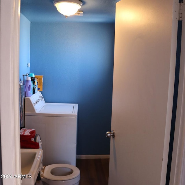 bathroom featuring washer / dryer, toilet, hardwood / wood-style flooring, and sink
