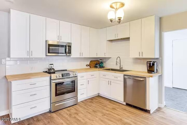 2723 Towell St, Overgaard, AZ 85933 - kitchen with stainless steel appliances, a sink, tasteful backsplash, and white cabinetry