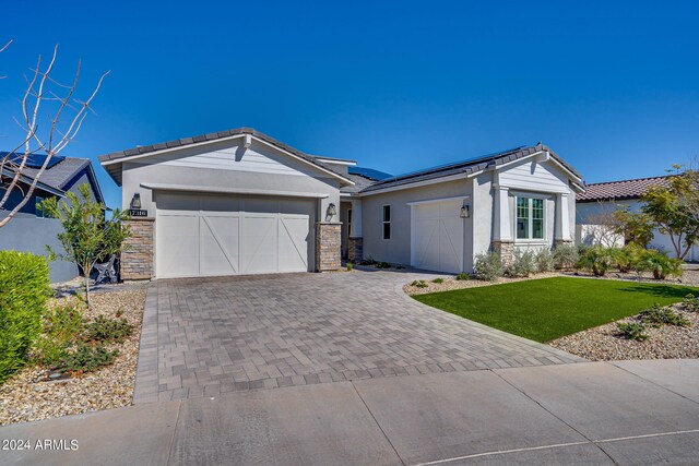 ranch-style home featuring a front lawn and a garage