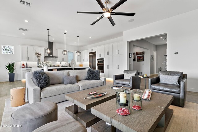 living room featuring light hardwood / wood-style flooring and ceiling fan