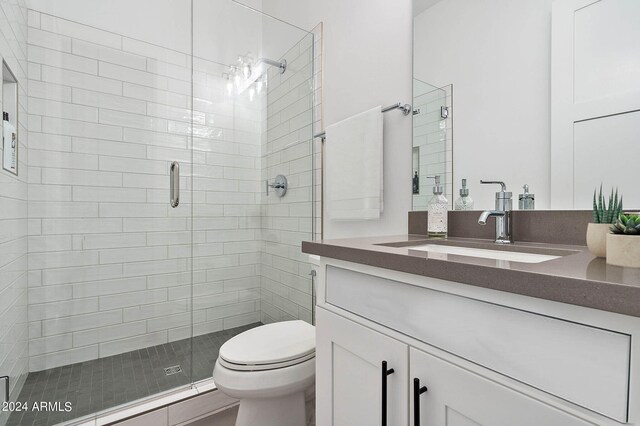 bathroom with an enclosed shower, toilet, and large vanity