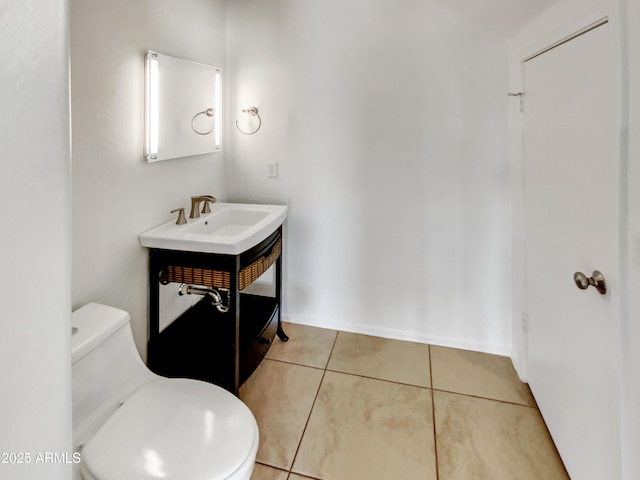 bathroom with toilet, sink, and tile patterned flooring