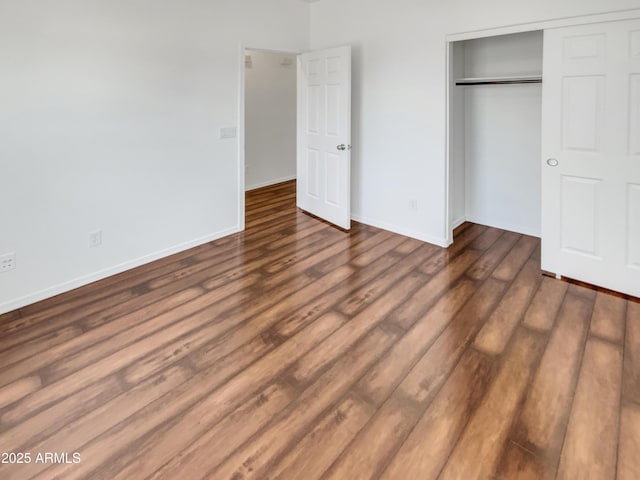 unfurnished bedroom featuring dark wood-type flooring and a closet