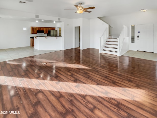 unfurnished living room featuring ceiling fan and light hardwood / wood-style floors