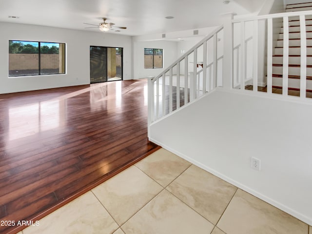 stairway with ceiling fan and hardwood / wood-style floors