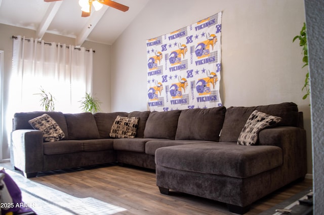 living area featuring a ceiling fan, lofted ceiling with beams, and wood finished floors