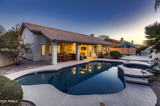 12754 E Laurel Ln, Scottsdale, AZ 85259 - pool at dusk featuring a patio, a fenced backyard, and a pool with connected hot tub