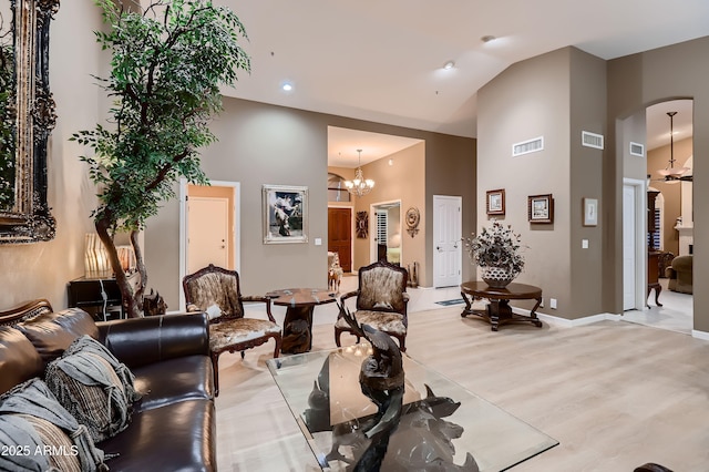 12754 E Laurel Ln, Scottsdale, AZ 85259 - living room with high vaulted ceiling, light wood-style floors, arched walkways, a chandelier, and baseboards