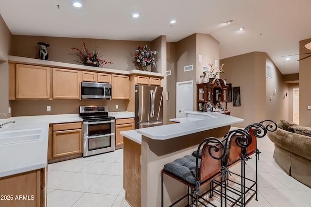 12754 E Laurel Ln, Scottsdale, AZ 85259 - kitchen with stainless steel appliances, light brown cabinets, light tile patterned floors, a sink, and light countertops