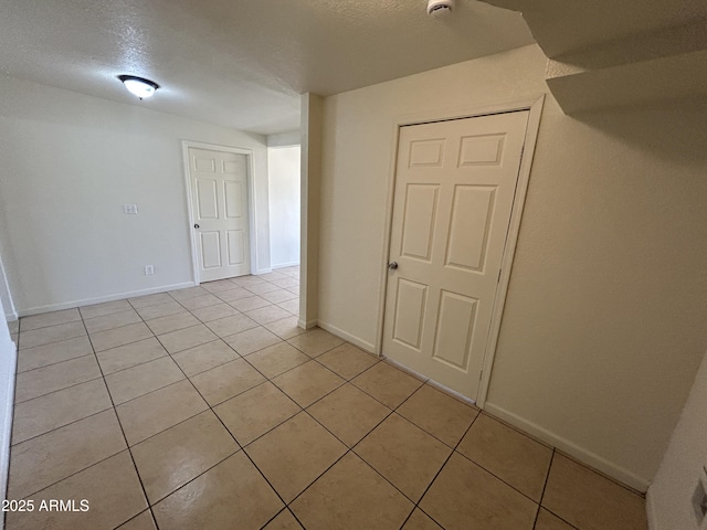 3814 N 55th Dr, Phoenix, AZ 85031 - spare room featuring light tile patterned flooring, baseboards, and a textured ceiling