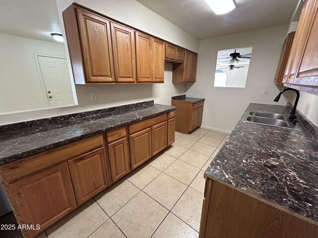 3814 N 55th Dr, Phoenix, AZ 85031 - kitchen featuring a sink, light tile patterned flooring, brown cabinets, ceiling fan, and a textured ceiling