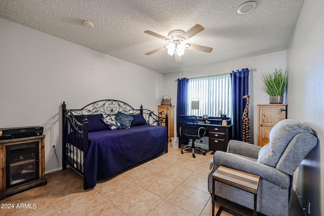 bedroom featuring ceiling fan, light tile patterned flooring, and a textured ceiling