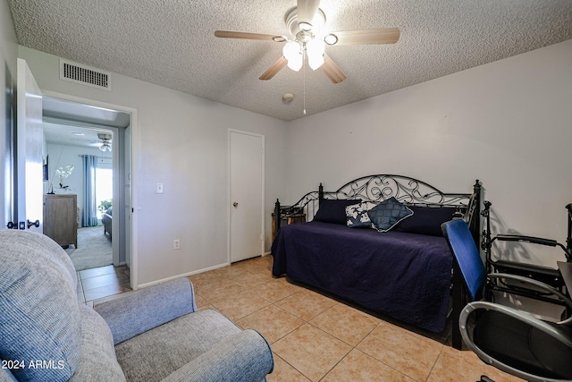 bedroom featuring light tile patterned floors, a textured ceiling, and ceiling fan