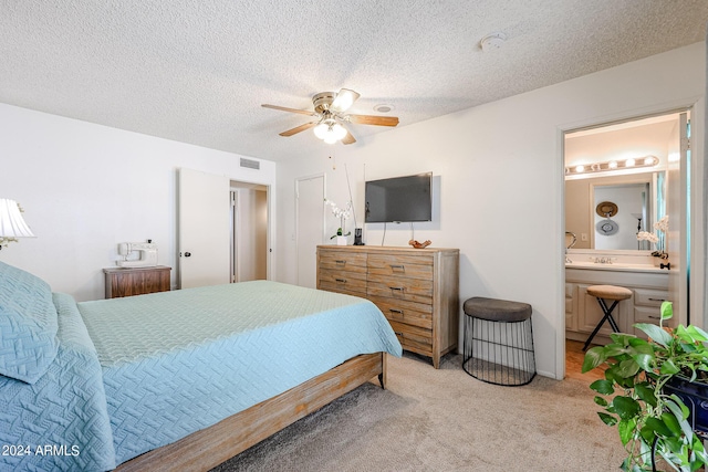 carpeted bedroom with connected bathroom, ceiling fan, and a textured ceiling