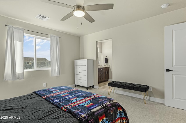 carpeted bedroom with ceiling fan and ensuite bath