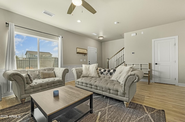 living room featuring wood-type flooring and ceiling fan