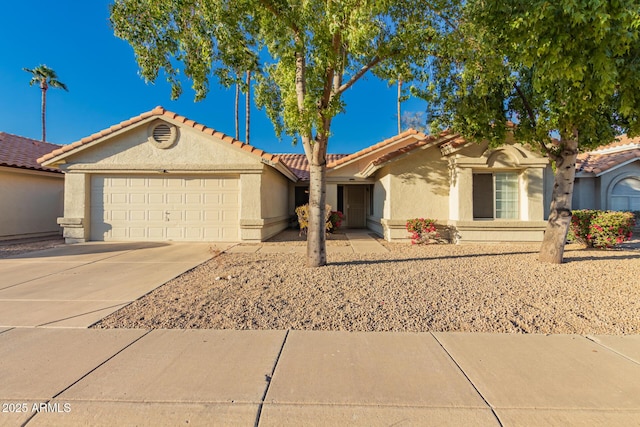 view of front facade with a garage, driveway, a tile roof, and stucco siding