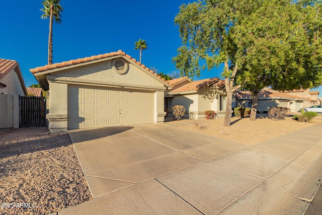 view of front facade with a garage, fence, a tile roof, concrete driveway, and stucco siding