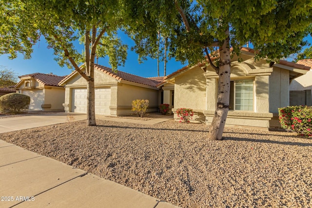 view of front of home featuring a garage, concrete driveway, a tile roof, and stucco siding