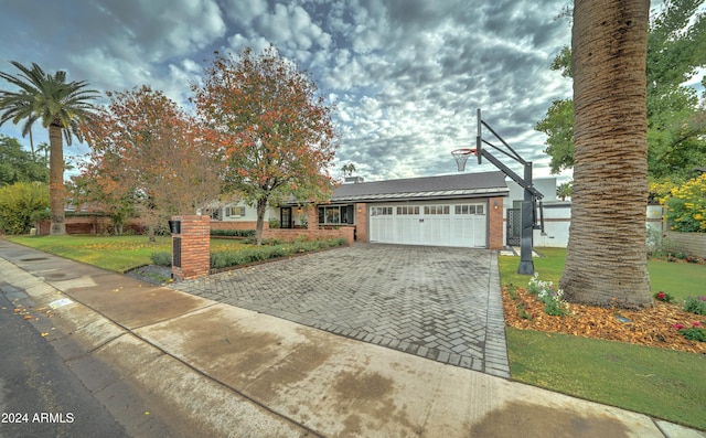 view of front of property featuring a garage and a front lawn