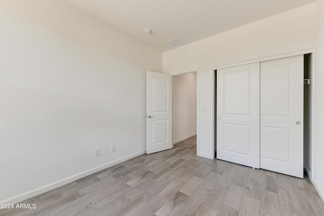 unfurnished bedroom featuring a closet and light hardwood / wood-style flooring