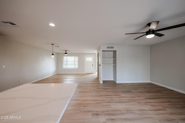 empty room with ceiling fan and light hardwood / wood-style flooring