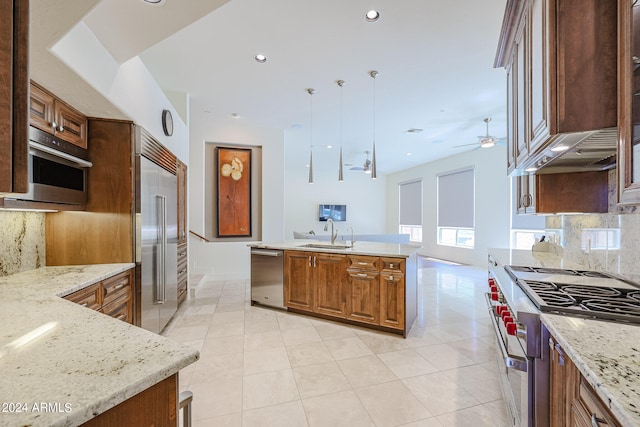 kitchen with hanging light fixtures, sink, ceiling fan, decorative backsplash, and high quality appliances