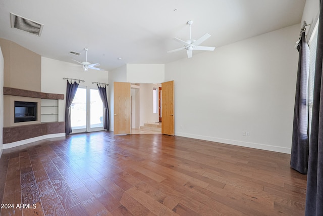 unfurnished living room featuring ceiling fan and dark hardwood / wood-style floors