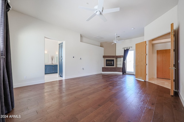 unfurnished living room with wood-type flooring and ceiling fan