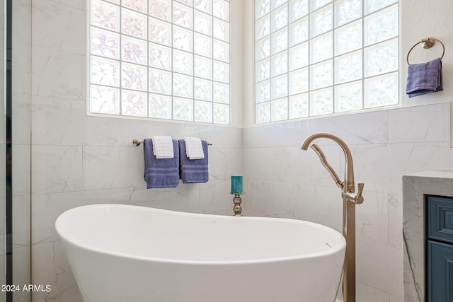 bathroom featuring tile walls and a bathing tub