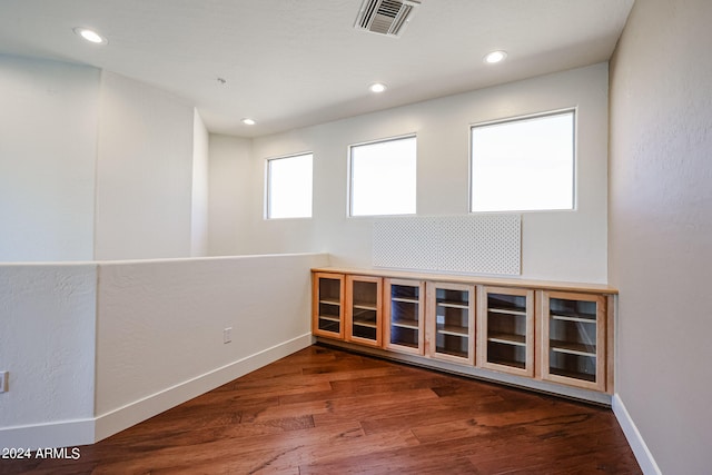 unfurnished room with dark wood-type flooring