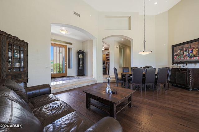 living room with a high ceiling and dark hardwood / wood-style flooring