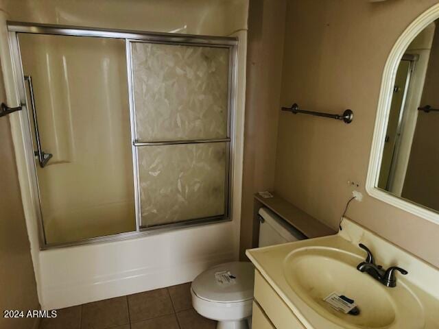 full bathroom featuring toilet, vanity, bath / shower combo with glass door, and tile patterned flooring