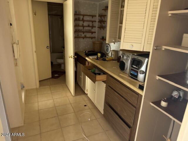 interior space with white cabinetry and light tile patterned flooring