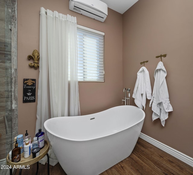 bathroom featuring an AC wall unit, a tub, and hardwood / wood-style floors