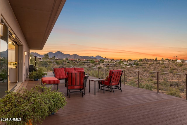 deck at dusk with a mountain view and an outdoor living space