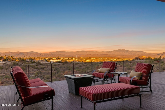 deck at dusk featuring a mountain view and an outdoor fire pit