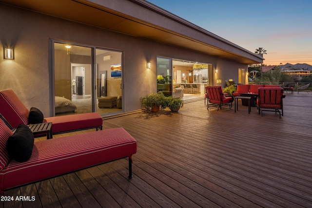 deck at dusk featuring an outdoor living space