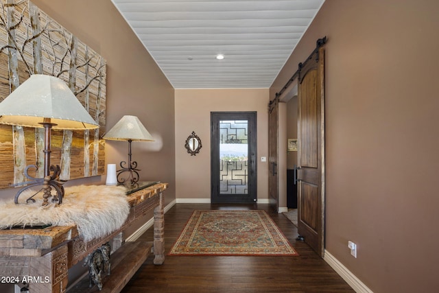 foyer entrance featuring a barn door and dark hardwood / wood-style flooring