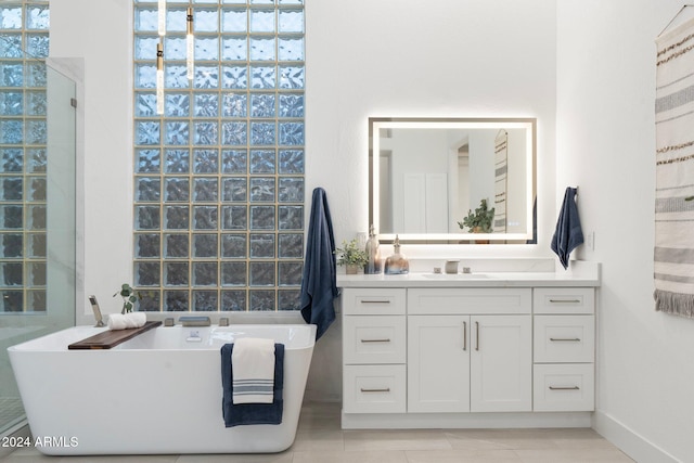 bathroom with tile patterned flooring, a bath, and vanity