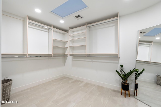 walk in closet with light hardwood / wood-style floors