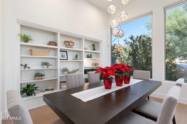 dining area with wood-type flooring and a chandelier