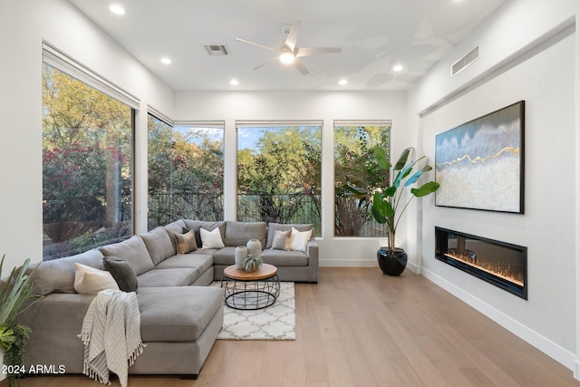 living room with ceiling fan and light hardwood / wood-style flooring