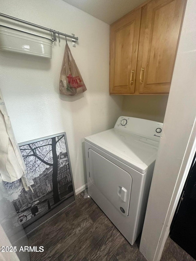 washroom featuring washer / dryer, dark wood-type flooring, and cabinets