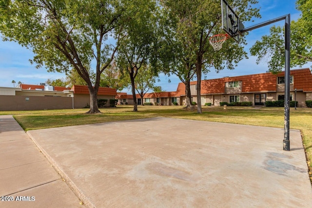 view of sport court with a lawn