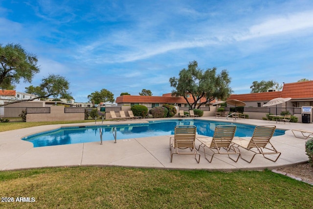 view of swimming pool featuring a yard and a patio