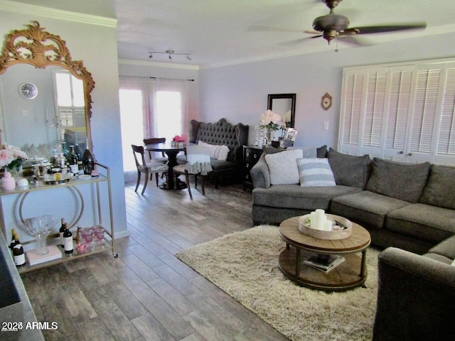 living room with crown molding, hardwood / wood-style flooring, rail lighting, and ceiling fan