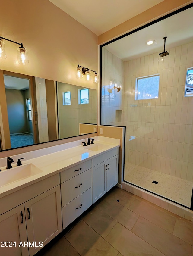 bathroom with vanity, a tile shower, and tile patterned floors