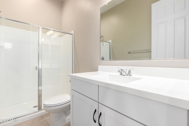 bathroom with a shower with door, vanity, toilet, and tile patterned flooring